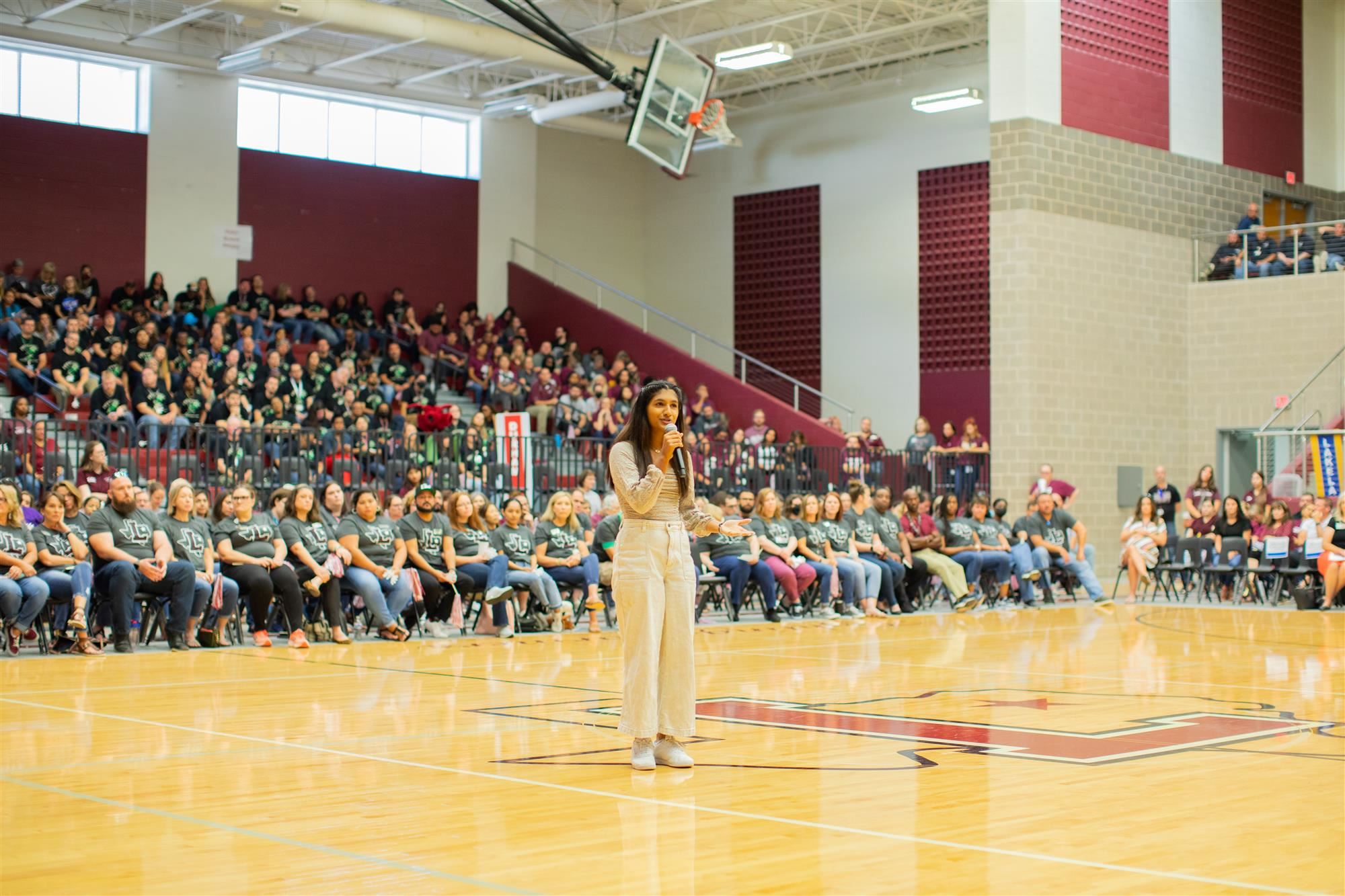 LHS senior Sonkia Harish addresses the teachers assembled in the LHS arena